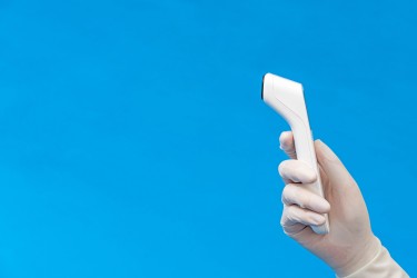 医疗工作者手拿测温仪侧面高清图