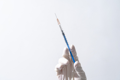右手拿医用针管注射器实拍图