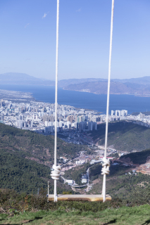 荡秋千旅游蓝天河流美景高清图