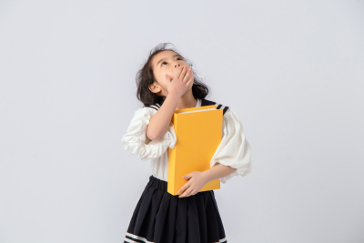 捂嘴大笑可爱小姑娘上学实拍图