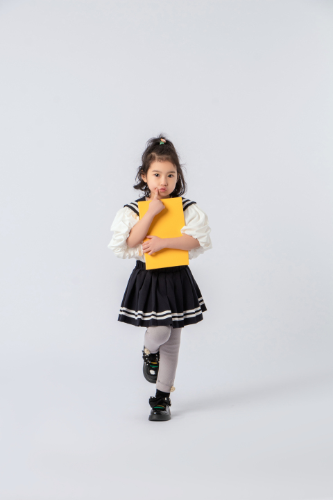 小学生上学图书嘟嘴小女孩实拍图版权图片下载