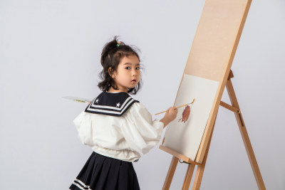 画板前努力画画的可爱女孩图