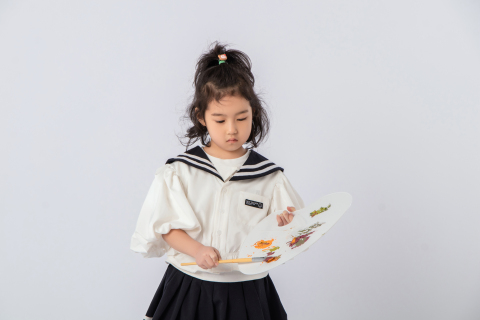 低头绘画调色的可爱女孩图