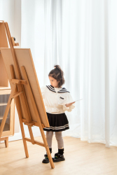 画板前认真作画的小女孩实拍图