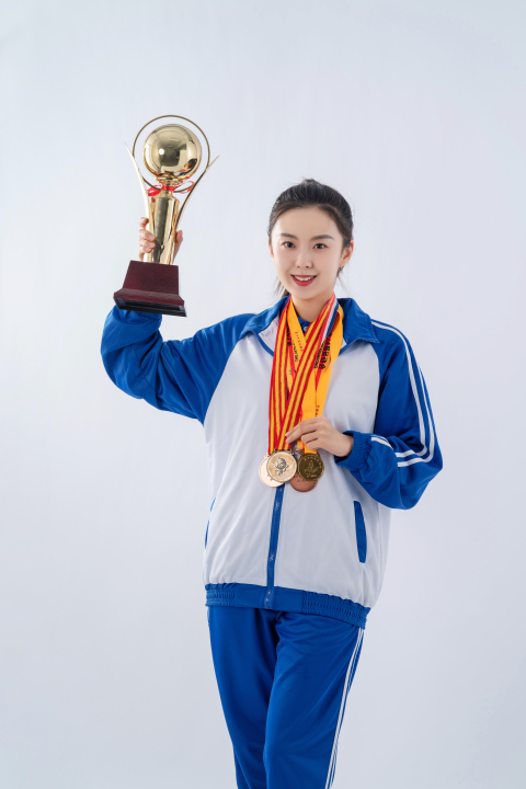 拿着奖杯面向镜头的女大学生高清图版权图片下载