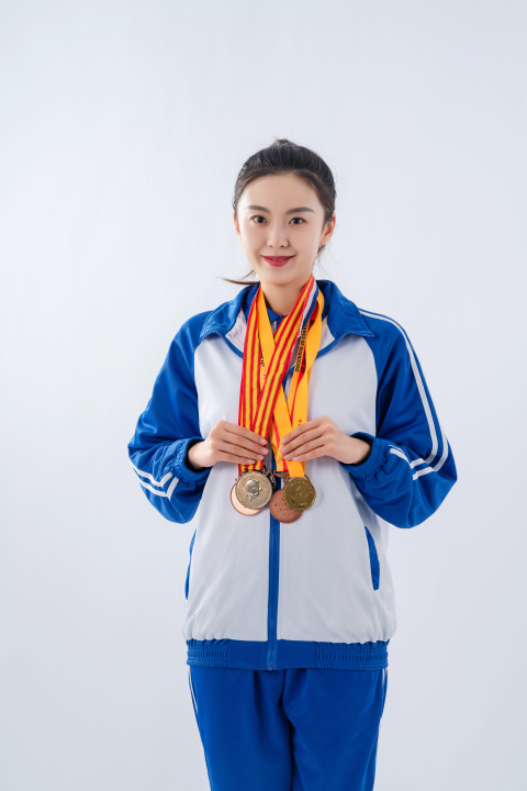 面对镜头的挂满奖牌的女运动员高清图版权图片下载