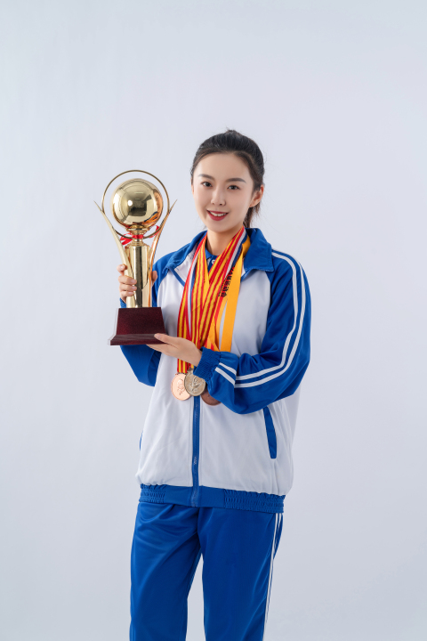 手托大奖杯脖挂奖牌的女生高清图版权图片下载
