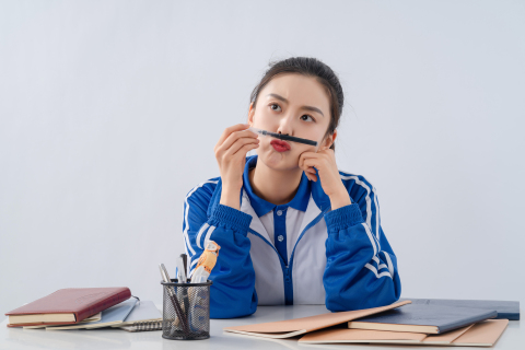 在课堂上坐着玩笔的女生高清图