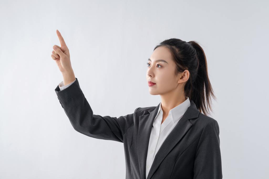 抬手指某处的职场女白领实拍图版权图片下载