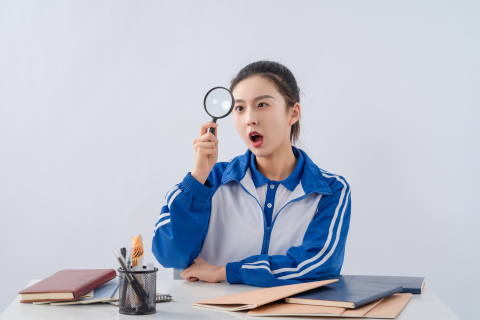 看着放大镜惊讶的女生高清图