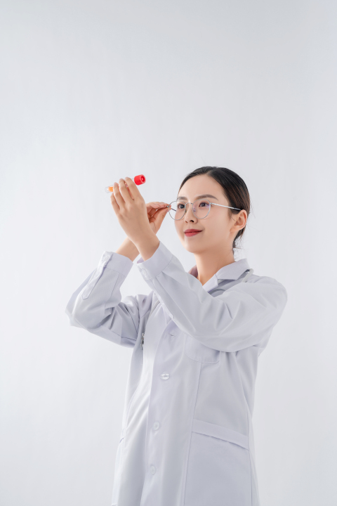 手拿试管抬头观察的女医生实拍图版权图片下载
