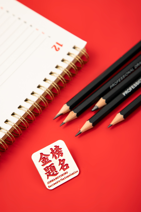 红色背景上的文具和金榜题名方牌高清图版权图片下载