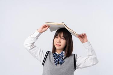 头顶书本眺望远方的学生实拍图