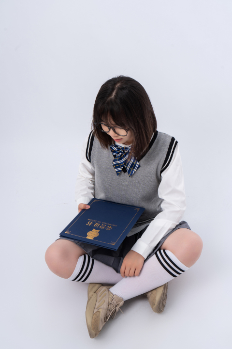 低头查看荣誉证书的学生实拍图版权图片下载