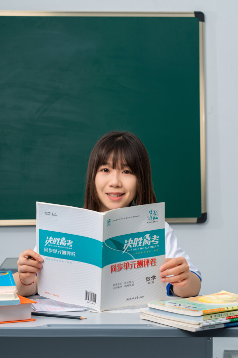 拿着课本专注学习的女生高清图版权图片下载