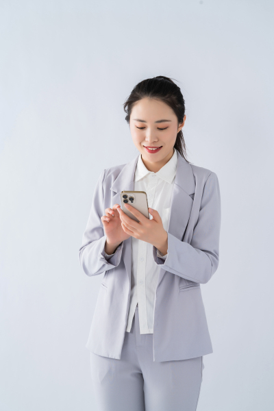 低头看手机的商务女性实拍图