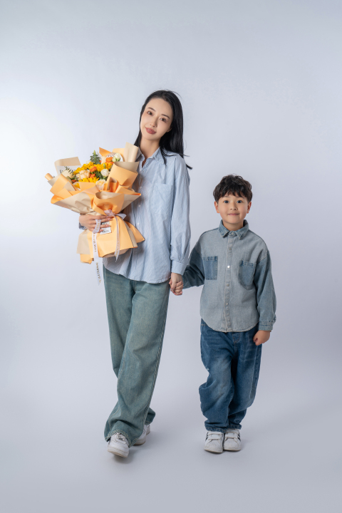 领着送花的儿子一块拍照的妈妈高清图版权图片下载