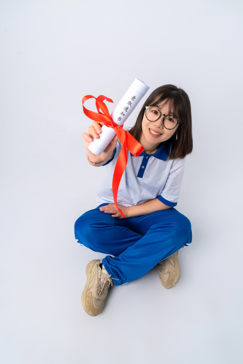 坐姿拿着成绩单的女学生高清图版权图片下载