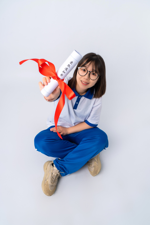 坐姿展示喜报的女学生高清图版权图片下载