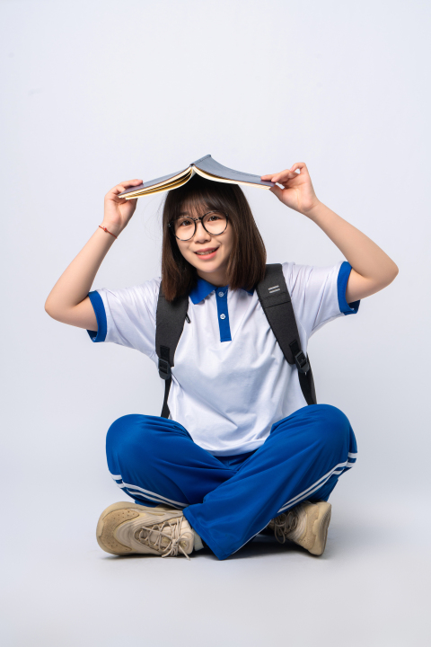 坐姿举书的女学生高清图版权图片下载