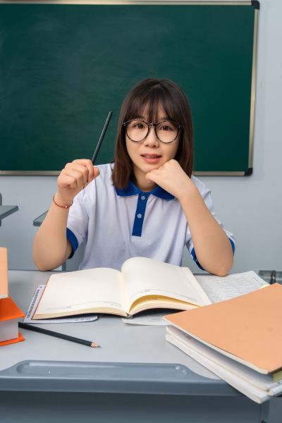 课桌上面的书本和学生高清图