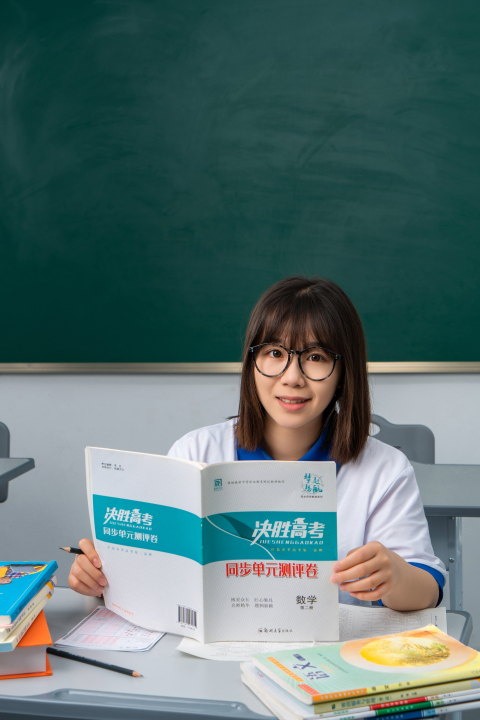 竖立课本读书的女生高清图版权图片下载