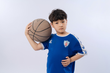 左手抱球的男孩高清图