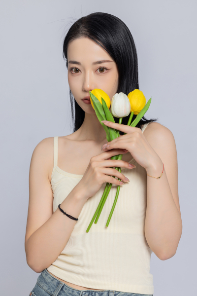 女性手持郁金香遮挡面部实拍图