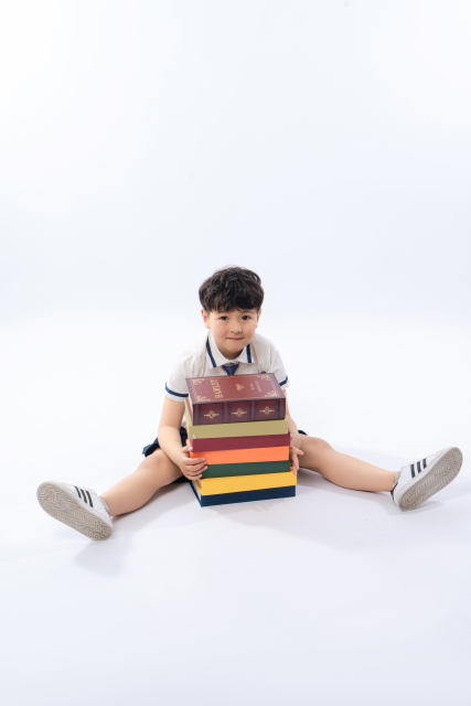 瘫坐在地上的看书小男生高清图