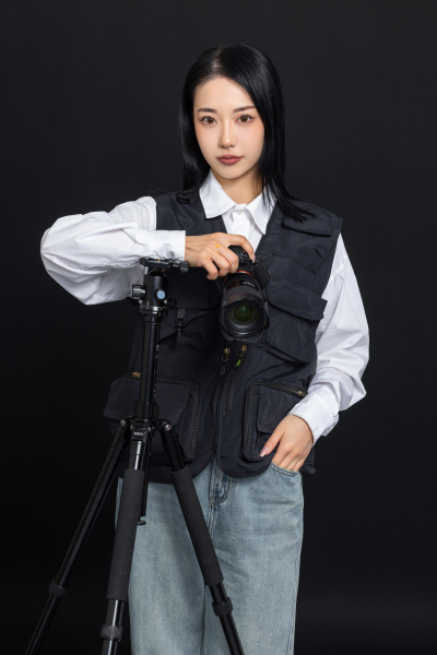 调整三脚架的女摄影师高清图