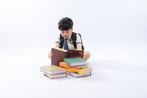 双手捧书观看的小学生高清图