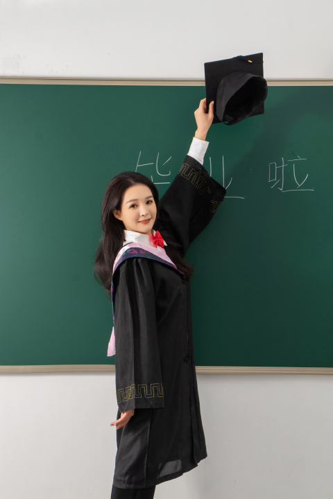 高举博士帽的毕业女生高清图版权图片下载