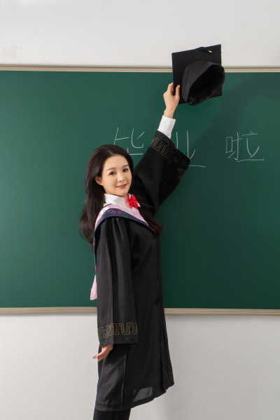 高举博士帽的毕业女生高清图