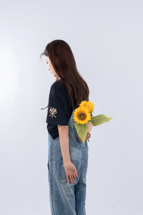 手拿向日葵女孩背影图版权图片下载