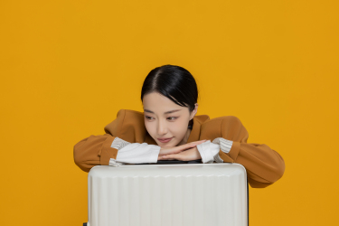 趴在行李箱上的乖巧女生高清图