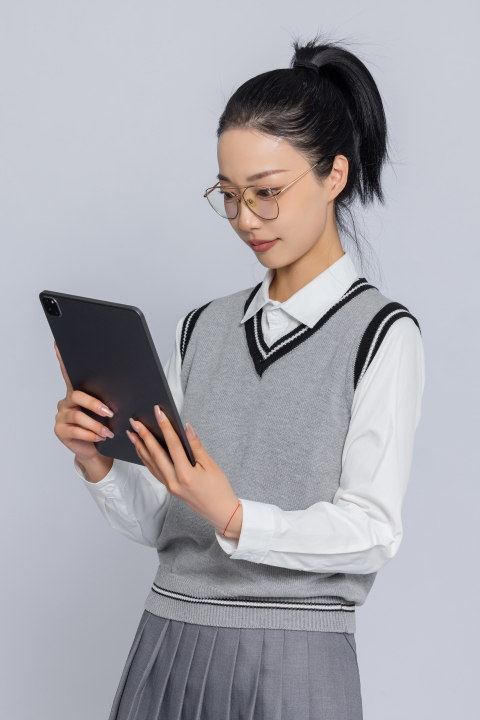 正在斜着身子看笔记的女学生高清图版权图片下载