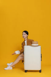 坐在行李箱后面休息的女生实拍图
