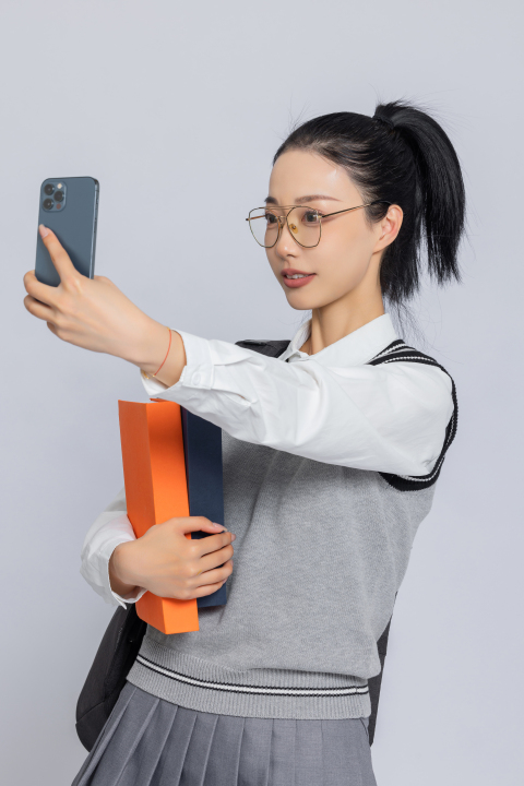 右手拿手机拍照大学生写真图版权图片下载