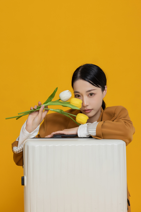 趴在行李箱上的拿花女生高清图版权图片下载