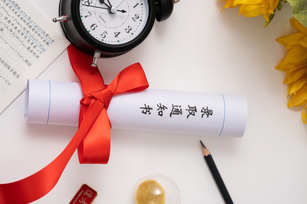 红色蝴蝶结绑着通知书实拍图版权图片下载